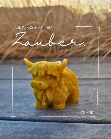 Gelbes Kuhspielzeug mit lockigem Fell vor einer natürlichen Hintergrundszene.