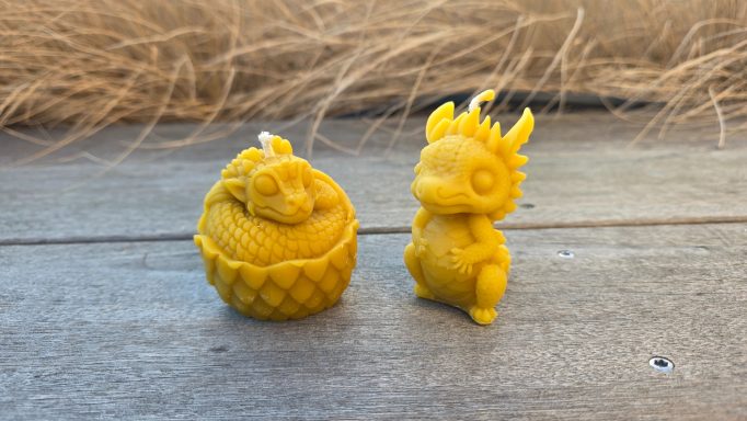 Zwei gelbe Miniaturfiguren: eine Ananas und ein kleiner Drache.